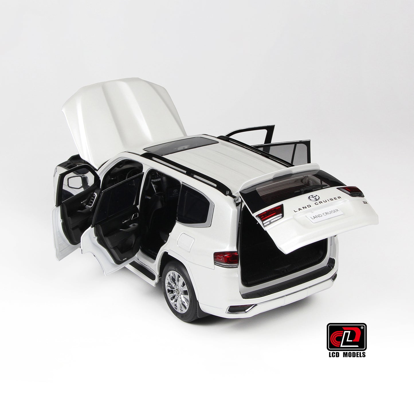 Model car of a Land Cruiser 300-ZX white with open doors and trunk on a white background
