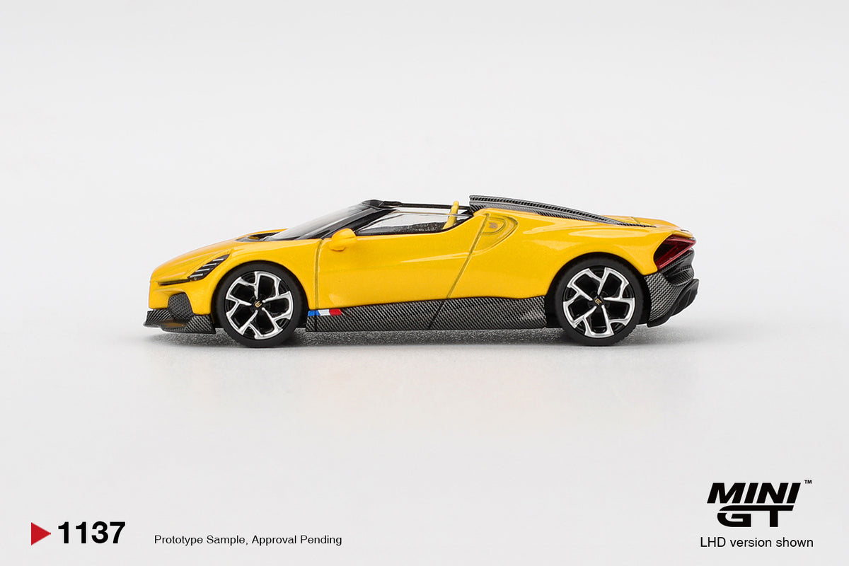 Mini GT Bugatti W16 Mistral yellow 1:64 scale diecast model car, side profile showing the exposed carbon fibre sills and yellow-faced multi-spoke wheels