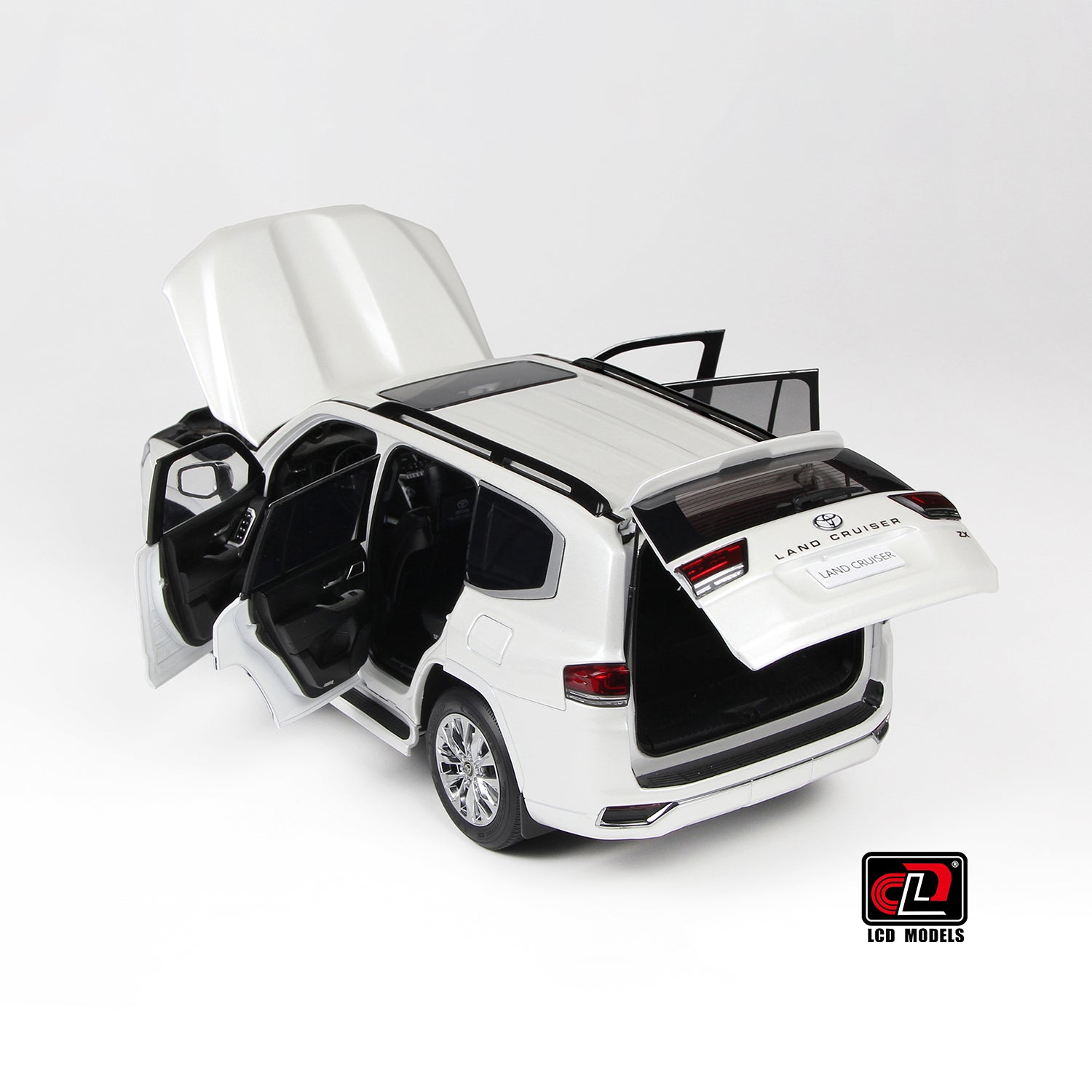 Model car of a Land Cruiser 300-ZX white with open doors and trunk on a white background