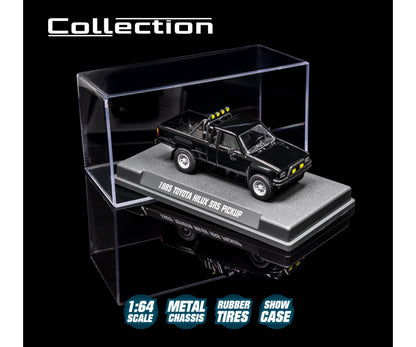 1985 Toyota Hilux SR5 Pickup Black 1:64 Scale Model Car – Majorette Premium (Product Code: 8505001016) in a clear display case with branding and product details.