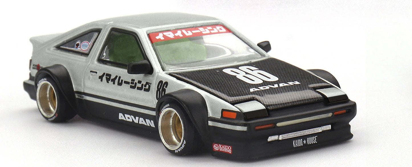 Front three-quarter view of Toyota AE86 Sprinter Trueno Kaido Street V2 silver and black 1:64 diecast model car by Kaido House x Mini GT with carbon bonnet and race number 86 (KHMG0218)