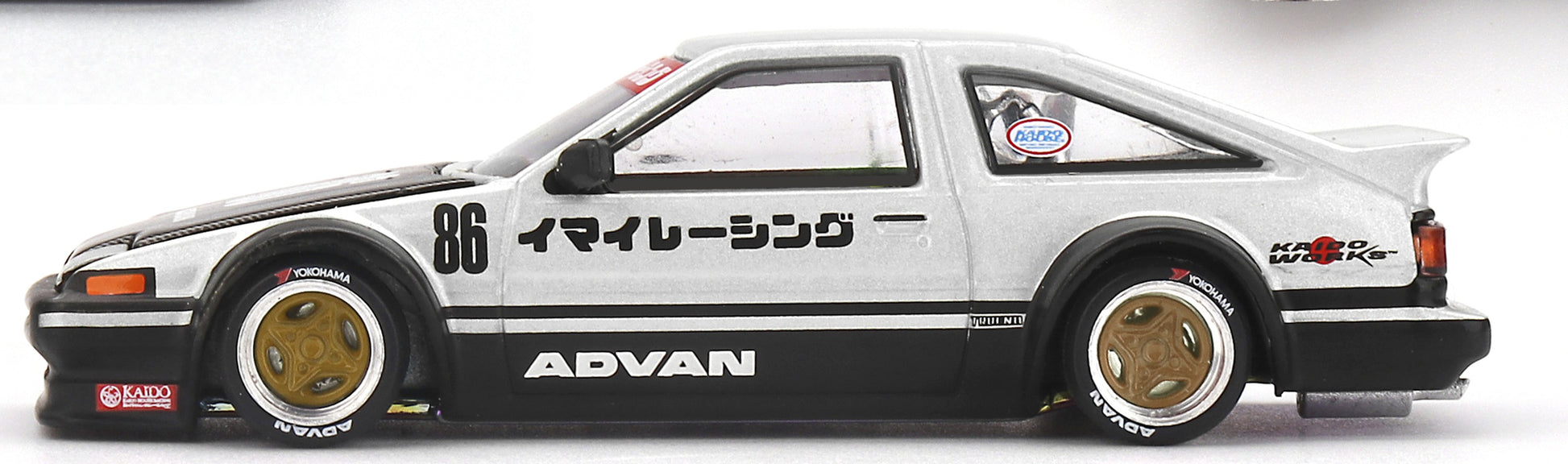 Side profile of Toyota AE86 Sprinter Trueno Kaido Street V2 1:64 scale model car showing the ADVAN Imai Racing livery and over-fenders (KHMG0218)