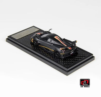 Rear three-quarter view of Pagani Imola matte carbon 1:64 diecast showing the rear wing and gold-outlined haunches (LCD64041-MBC)