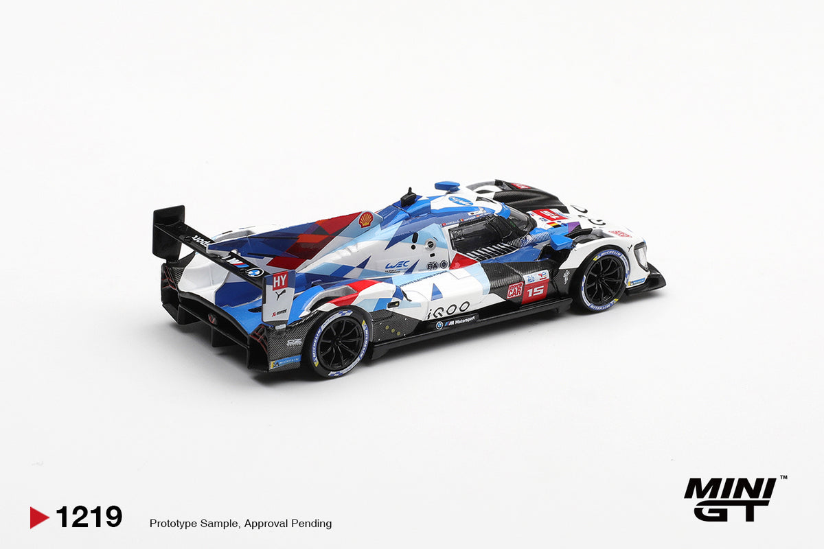 Mini GT BMW M Hybrid V8 Hypercar #15 white and blue 1:64 scale diecast model car, rear three-quarter view showing the shark-fin engine cover and rear wing