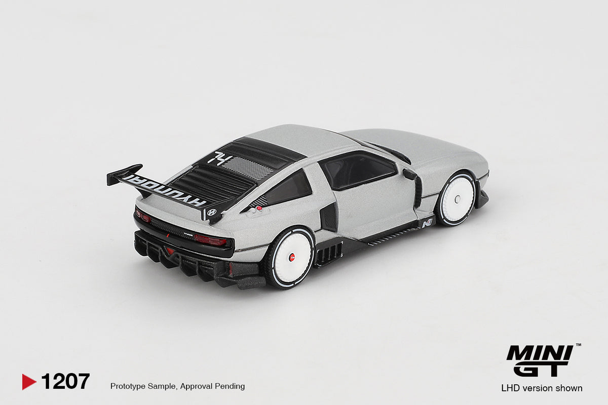 Mini GT Hyundai Concept N Vision 74 (VP2) silver 1:64 scale diecast model car, rear three-quarter view showing the tall HYUNDAI rear wing and 74 roof graphic