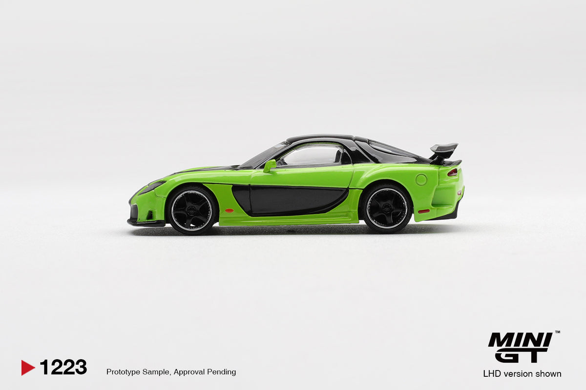 Side profile of Mazda RX-7 VeilSide Fortune7 green 1:64 scale model car showing the smooth Fortune widebody flanks and dark multi-spoke wheels (MGT01223)