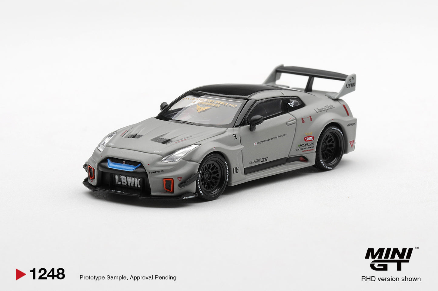 Front three-quarter view of Nissan LB-Silhouette WORKS GT 35GT-RR Ver.1 Matt Grey 1:64 diecast model car by Mini GT showing the LBWK front lip and blue light bar (MGT01248)